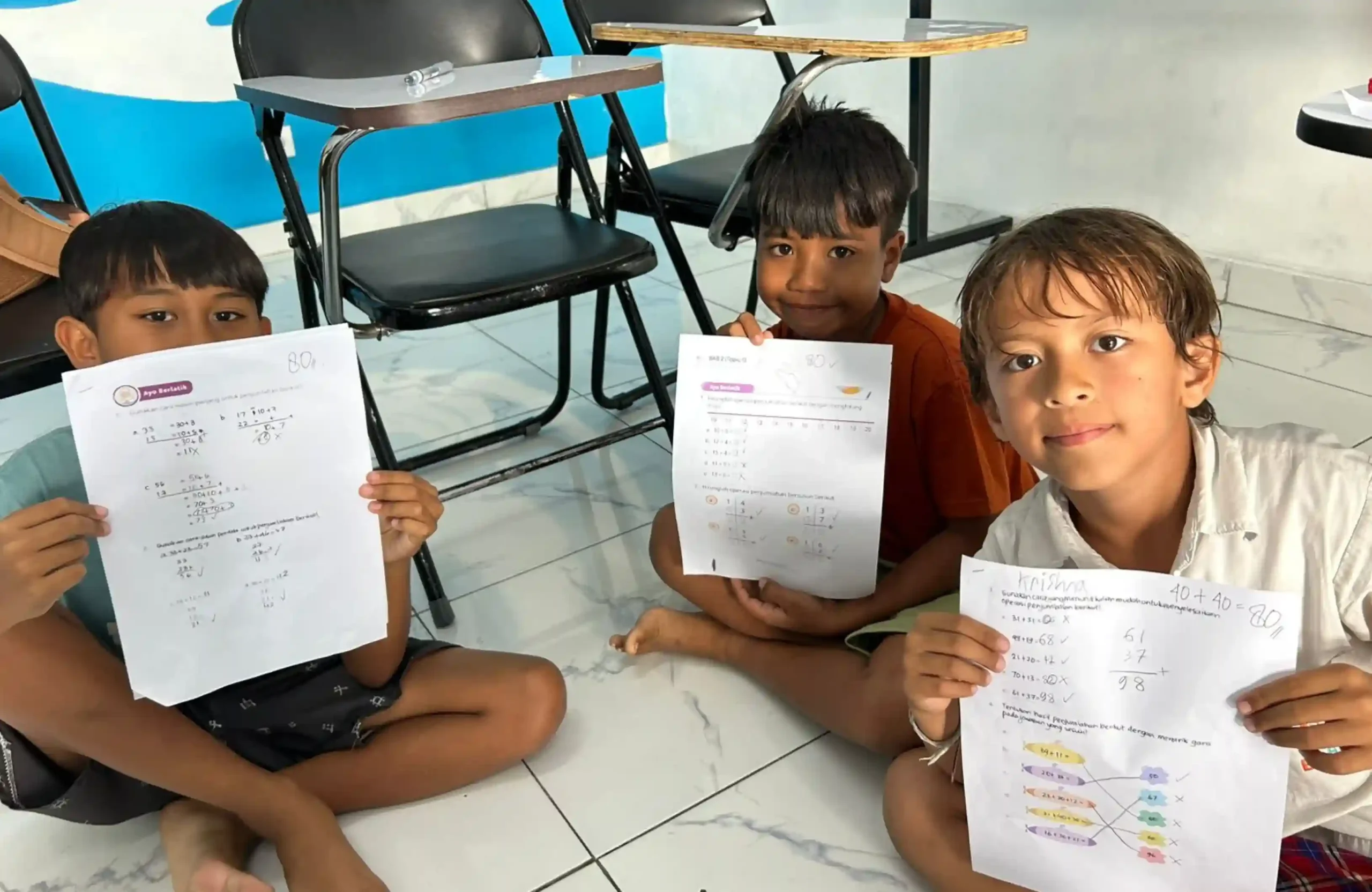 Anak-anak mengikuti les matematika Bali dan menunjukkan hasil latihan berhitung